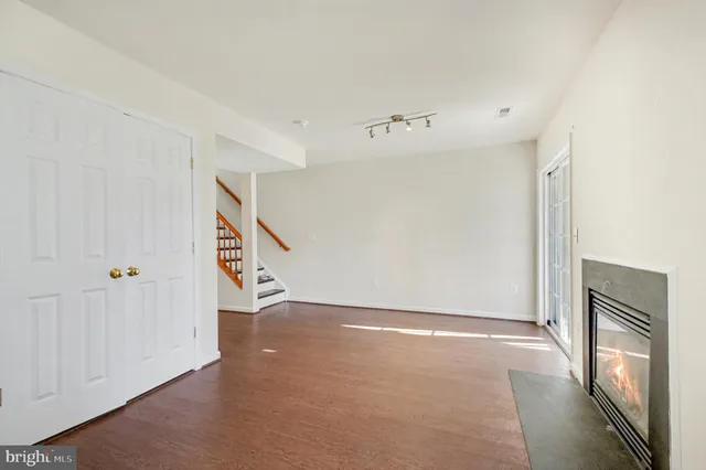 a view of an empty room with stairs and a hallway
