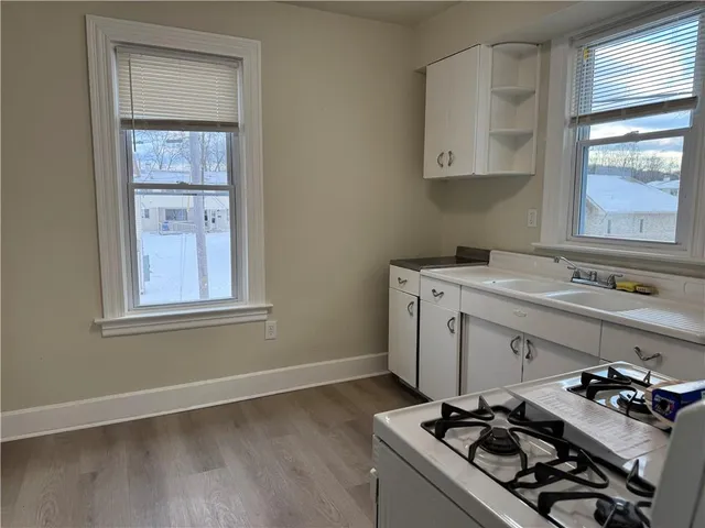 a kitchen with a stove a sink and a window