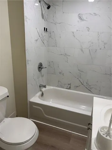 a bathroom with a white toilet and a bathtub