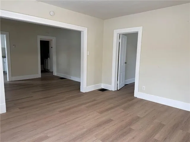 an empty room with wooden floor and closet