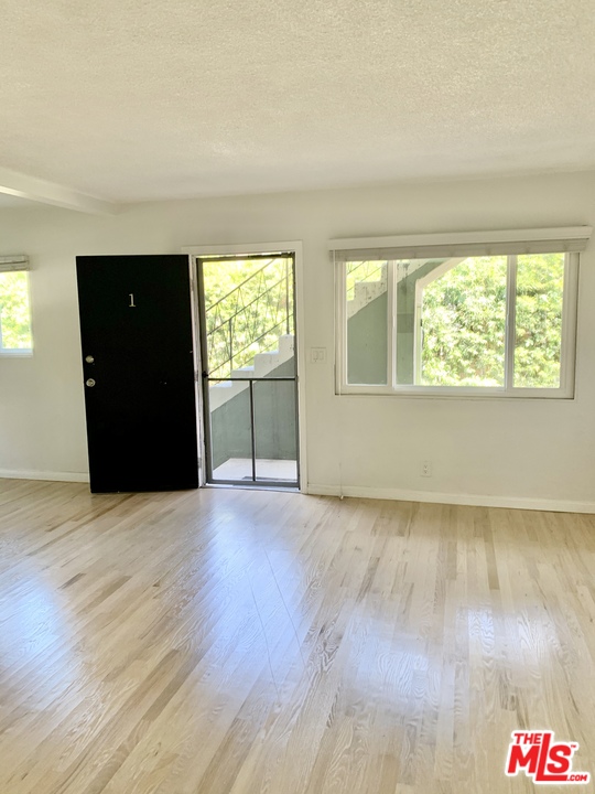 3040 Exposition Boulevard, Unit 1 Santa Monica, CA 90404 - Photo 3 of 15 an empty room with wooden floor and windows