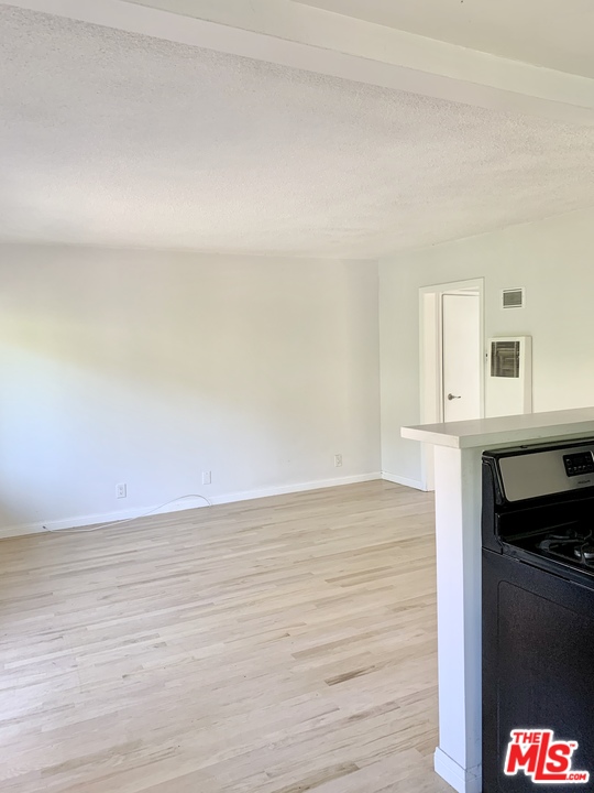 3040 Exposition Boulevard, Unit 1 Santa Monica, CA 90404 - Photo 10 of 15 a view of kitchen and empty room with wooden floor