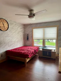 a bedroom with a bed and a large window