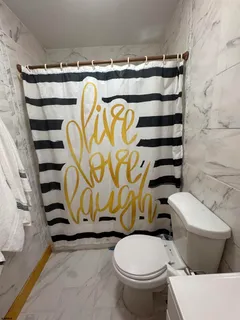 a bathroom with a toilet and a shower curtain