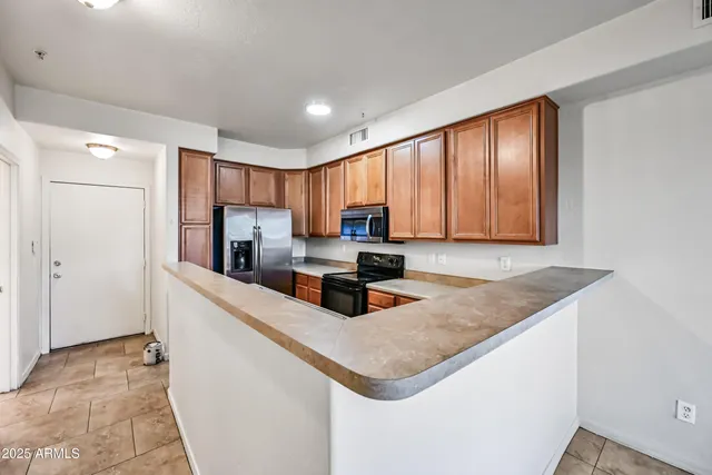 a kitchen with granite countertop a stove a sink and a refrigerator