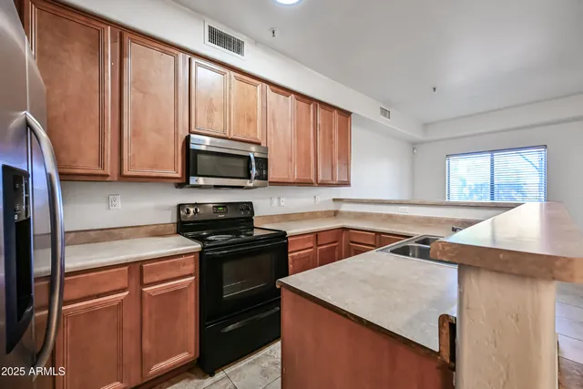 a kitchen with stainless steel appliances granite countertop a sink stove and microwave