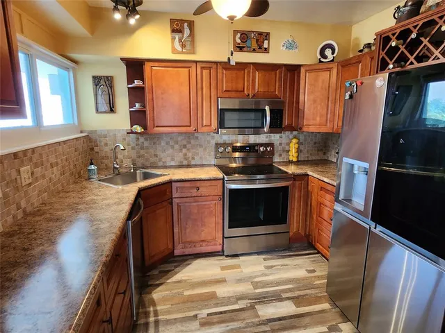 a kitchen with stainless steel appliances granite countertop a stove a sink and a refrigerator