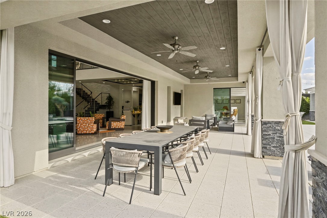4208 Lapis Ridge Court Las Vegas, NV 89135 - Photo 37 of 61 An expansive covered patio features a wood-paneled ceiling and tiled flooring alongside sliding glass doors.