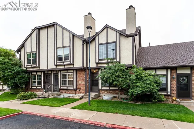 a front view of a house with a yard and potted plants