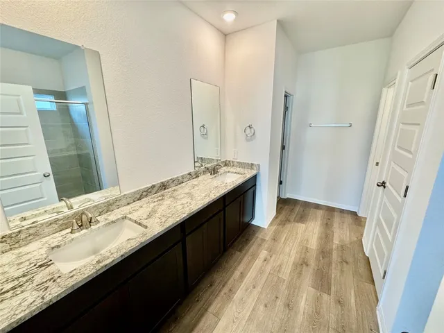 a bathroom with a granite countertop sink a toilet and shower