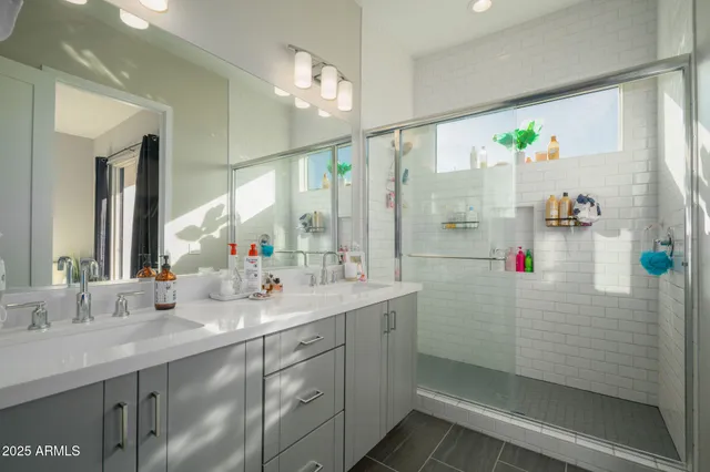 a bathroom with a shower sink and mirror