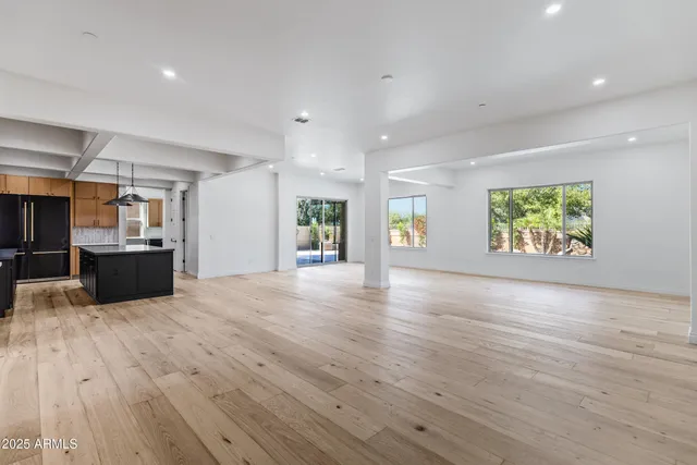 a view of kitchen and empty room with wooden floor