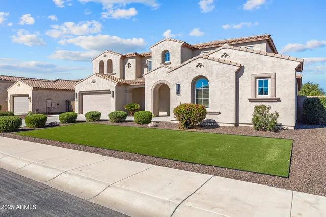 a front view of a house with a garden and plants