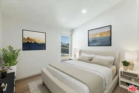 a bedroom with a large bed and a potted plant