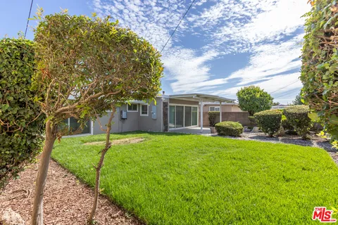a view of a house with backyard and a tree