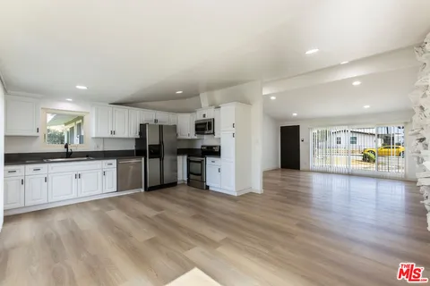 a large kitchen with stainless steel appliances granite countertop a large counter top and a stove