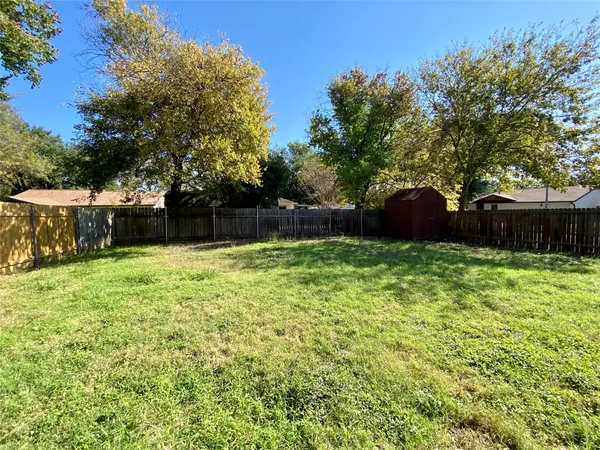 a view of a house with backyard and a tree