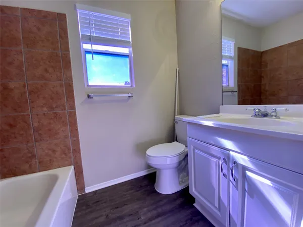 a bathroom with a granite countertop toilet sink and mirror