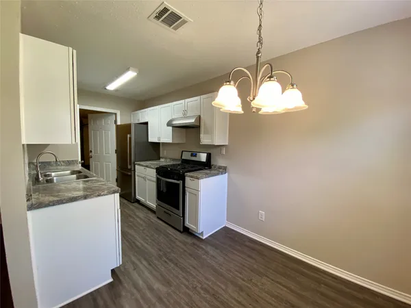 a kitchen with sink cabinets and wooden floor