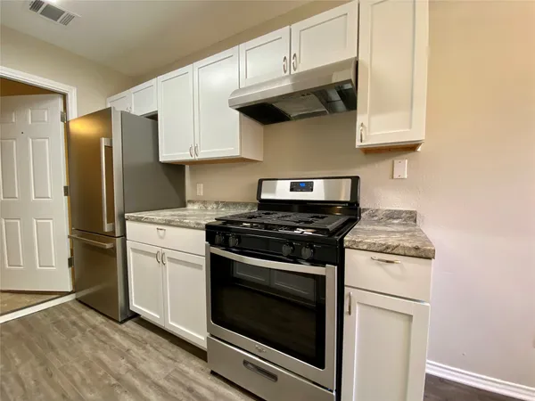 a kitchen with stainless steel appliances granite countertop a stove and a refrigerator