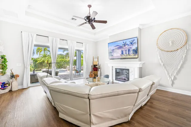 a living room with furniture a fireplace and a ceiling fan