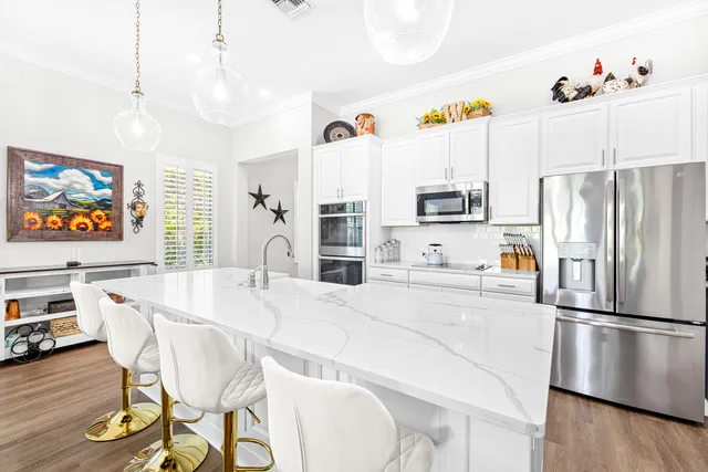 a kitchen with stainless steel appliances granite countertop a sink and a refrigerator