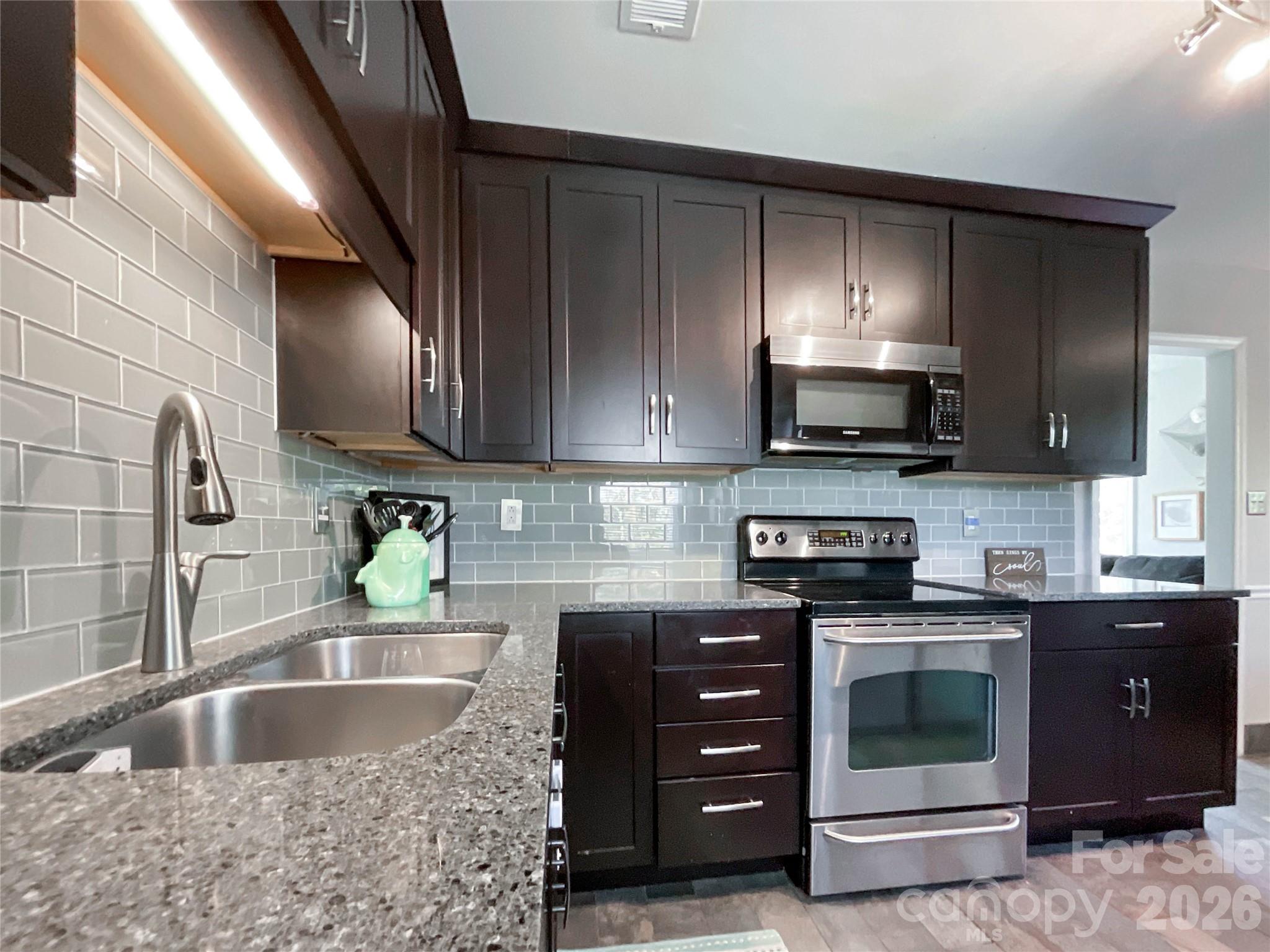 8004 Idlewild Road Indian Trail, NC 28079 - Photo 6 of 33 a kitchen with stainless steel appliances granite countertop a sink stove and microwave