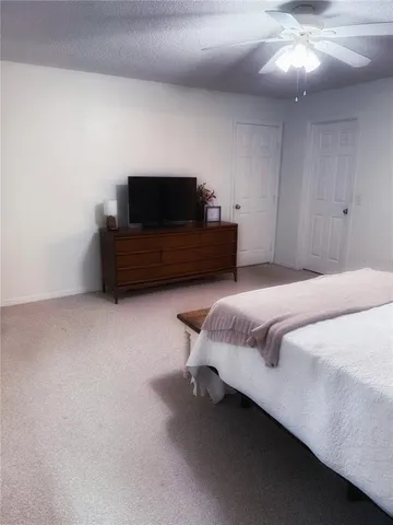 a bedroom with a bed and a ceiling fan