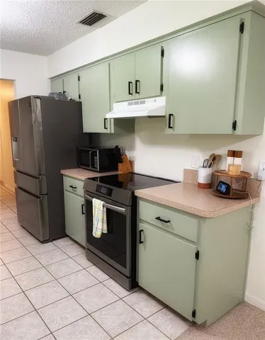 a kitchen with stainless steel appliances granite countertop a sink and a refrigerator
