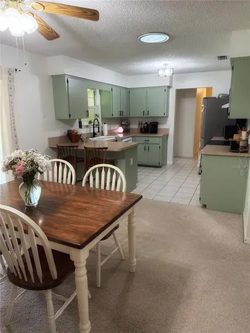 a kitchen with a dining table chairs stainless steel appliances and cabinets