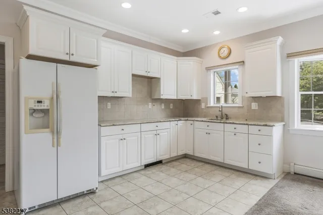 a kitchen with granite countertop cabinets and window