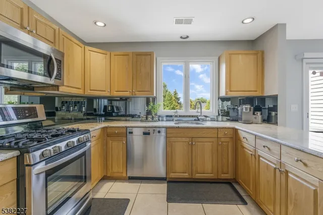 a kitchen with stainless steel appliances granite countertop a stove sink and cabinets