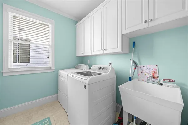 a bathroom with a sink a large mirror and a clock on the dresser