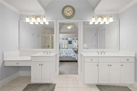 a bathroom with a sink a mirror and painting on the wall