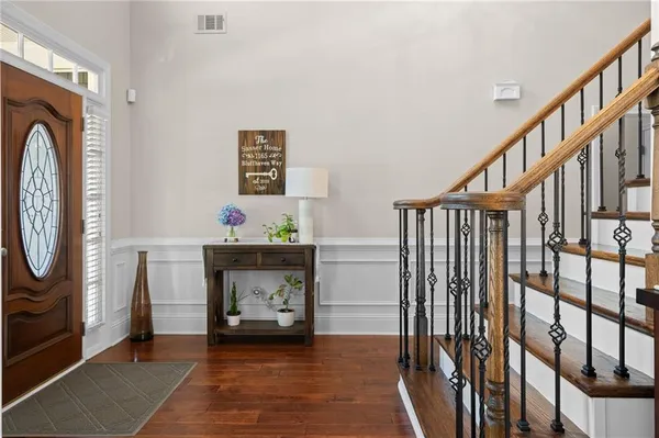 a kitchen with stainless steel appliances granite countertop a stove a refrigerator a sink dishwasher a dining table and chairs with wooden floor