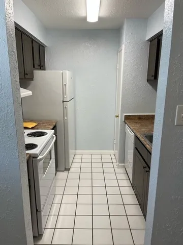 a kitchen with a refrigerator and a stove top oven