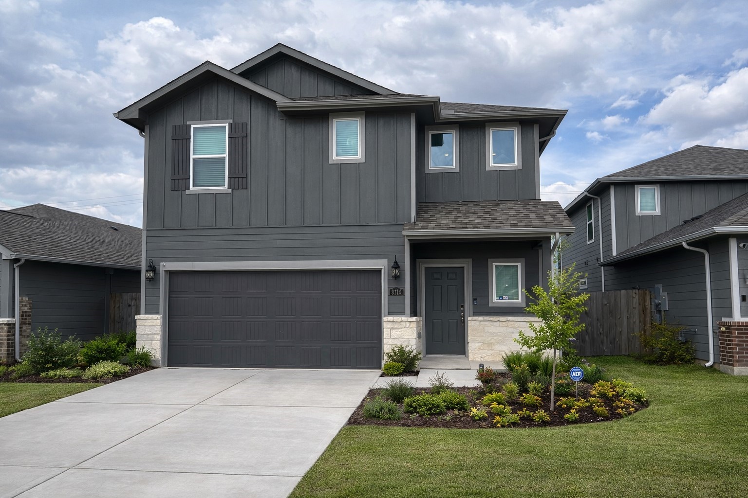 a front view of a house with a garden and garage