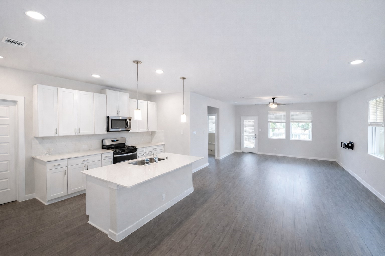 5715 Madden Lane Houston, TX 77048 - Photo 3 of 16 a kitchen with granite countertop a stove a sink a refrigerator and white cabinets with wooden floor