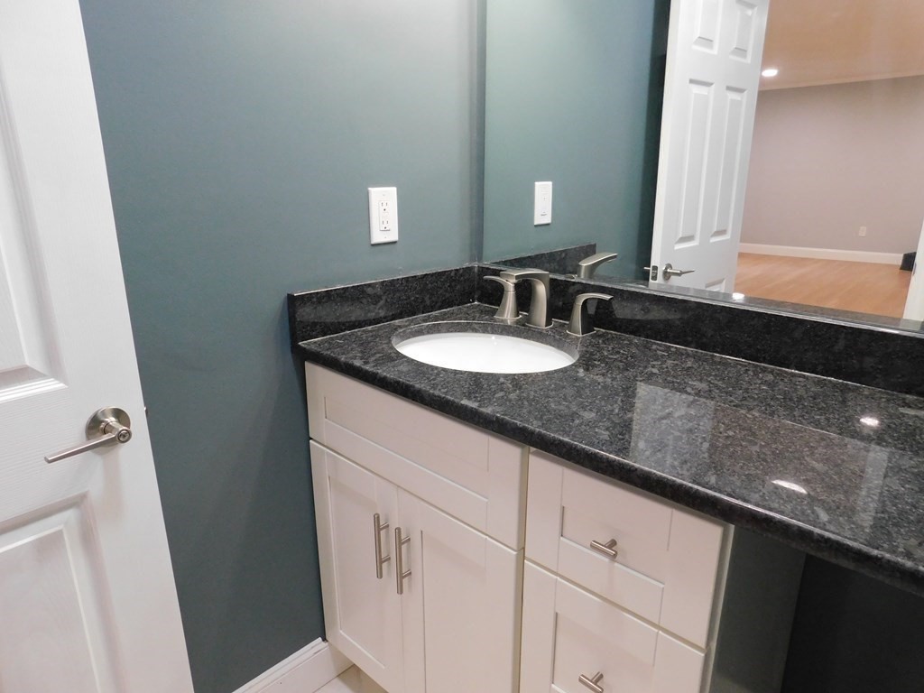 80 Mountain Gate Road, Unit 80 Ashland, MA 01721 - Photo 15 of 42 a bathroom with a granite countertop sink and a mirror