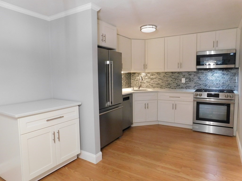 80 Mountain Gate Road, Unit 80 Ashland, MA 01721 - Photo 2 of 42 a kitchen with white cabinets and stainless steel appliances