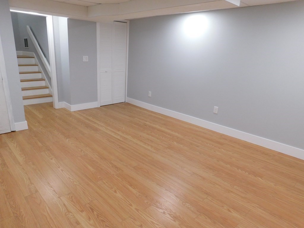 80 Mountain Gate Road, Unit 80 Ashland, MA 01721 - Photo 30 of 42 a view of an empty room with wooden floor and stairs