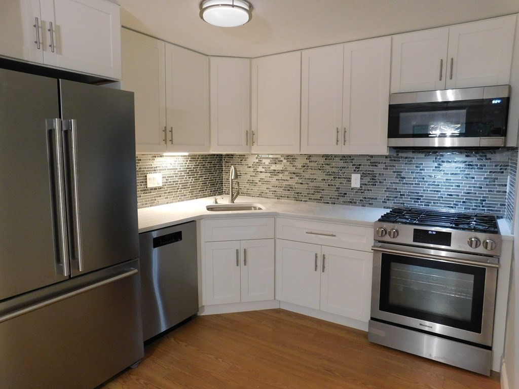 80 Mountain Gate Road, Unit 80 Ashland, MA 01721 - Photo 3 of 42 a kitchen with cabinets stainless steel appliances and wooden floor