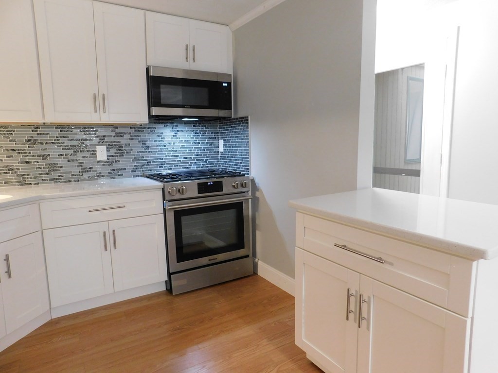 80 Mountain Gate Road, Unit 80 Ashland, MA 01721 - Photo 8 of 42 a kitchen with granite countertop white cabinets and stainless steel appliances