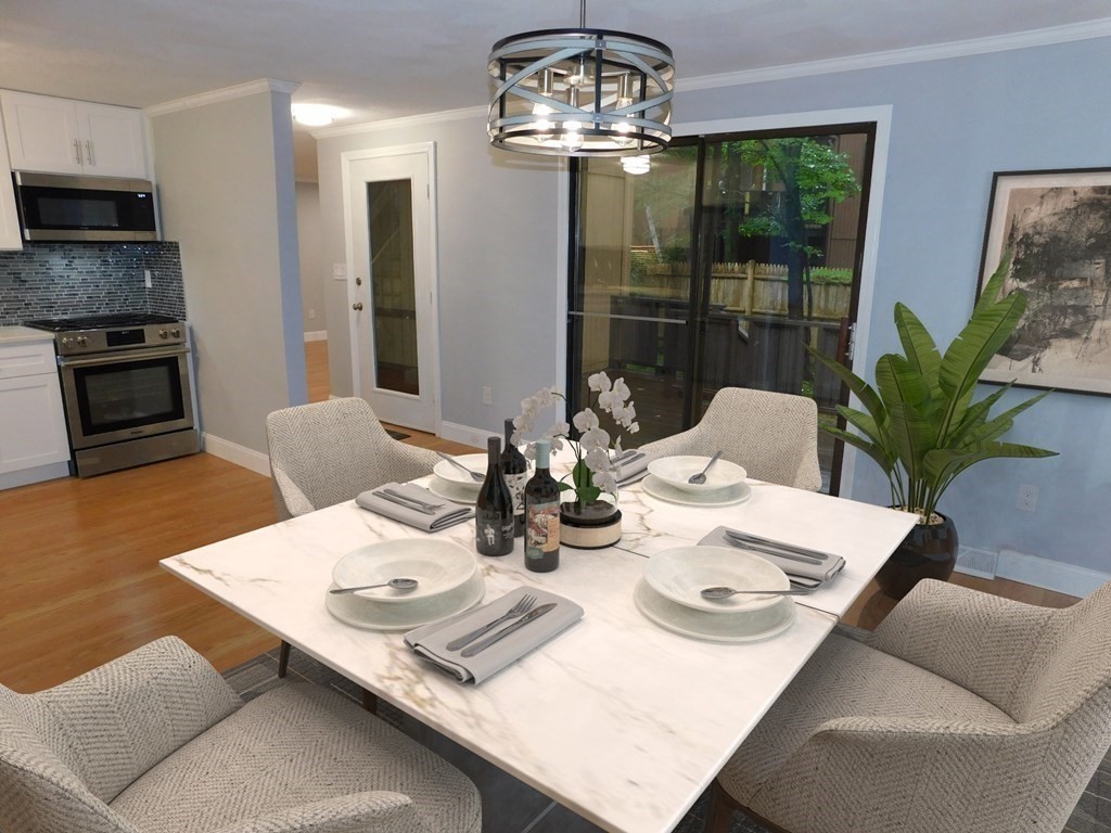 80 Mountain Gate Road, Unit 80 Ashland, MA 01721 - Photo 9 of 42 a view of a dining room with furniture a chandelier and wooden floor