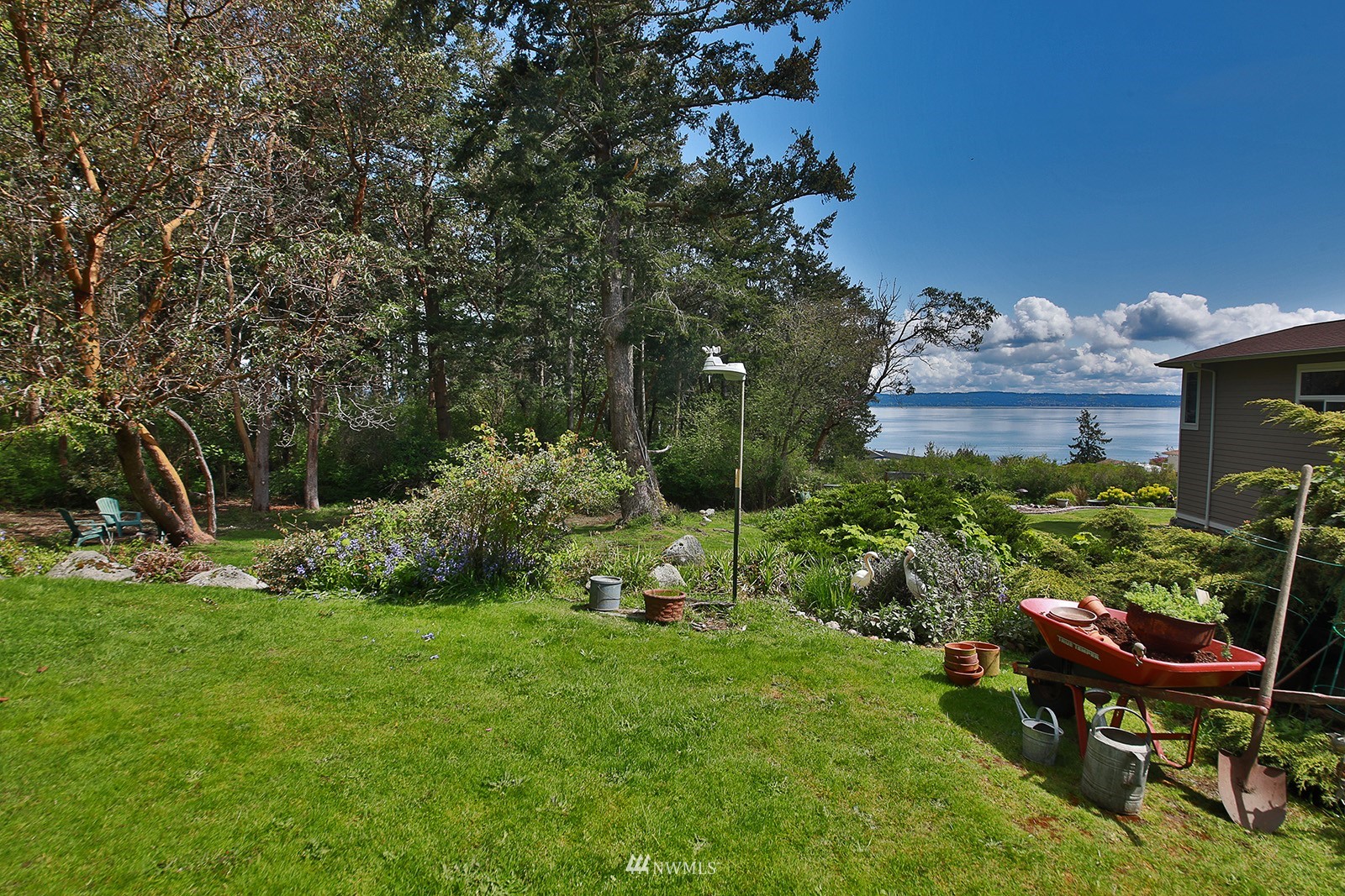1294 Bonnie View Acres Road Oak Harbor, WA 98277 - Photo 28 of 39 a backyard of a house with table and chairs plants and large tree