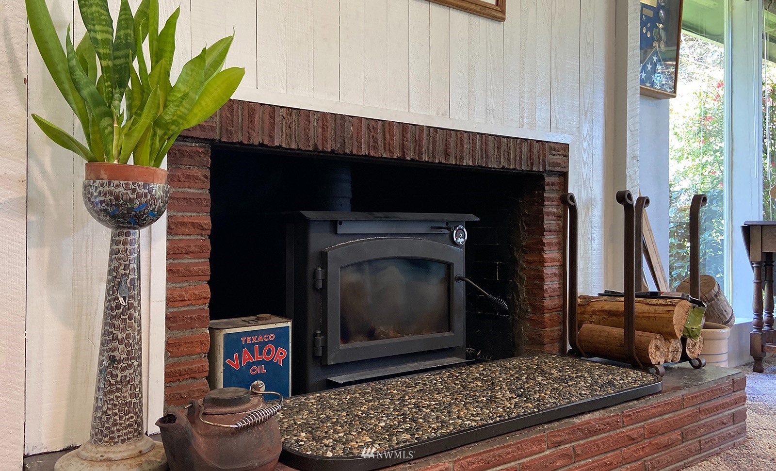 1294 Bonnie View Acres Road Oak Harbor, WA 98277 - Photo 8 of 39 a living room with a fireplace wooden floor and a potted plant
