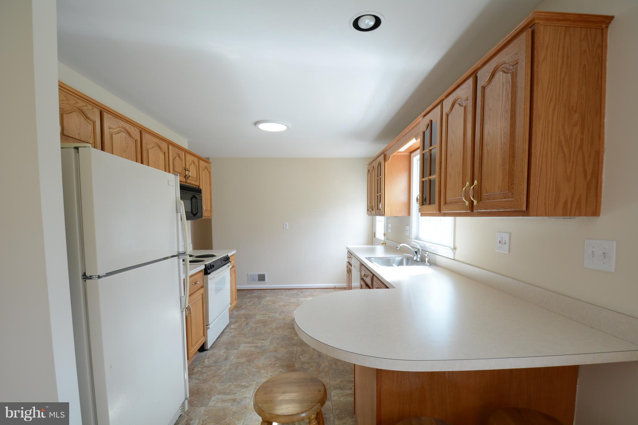 6505 Kalmia Street Springfield, VA 22150 - Photo 3 of 30 a kitchen with stainless steel appliances granite countertop a sink refrigerator and microwave