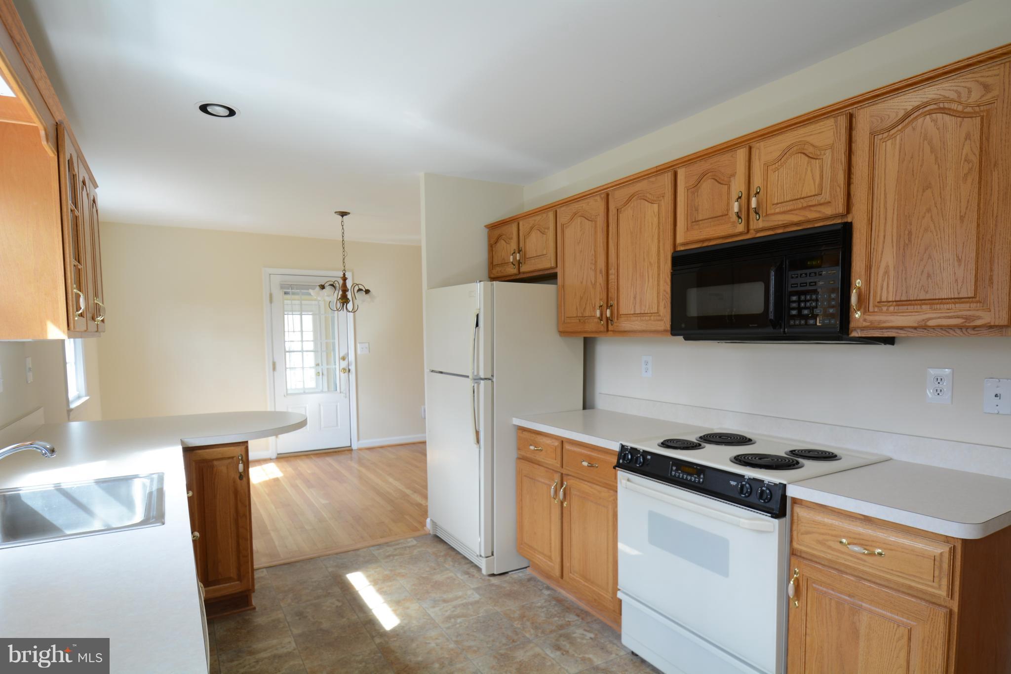 6505 Kalmia Street Springfield, VA 22150 - Photo 4 of 30 a kitchen with stainless steel appliances granite countertop a refrigerator stove microwave and sink