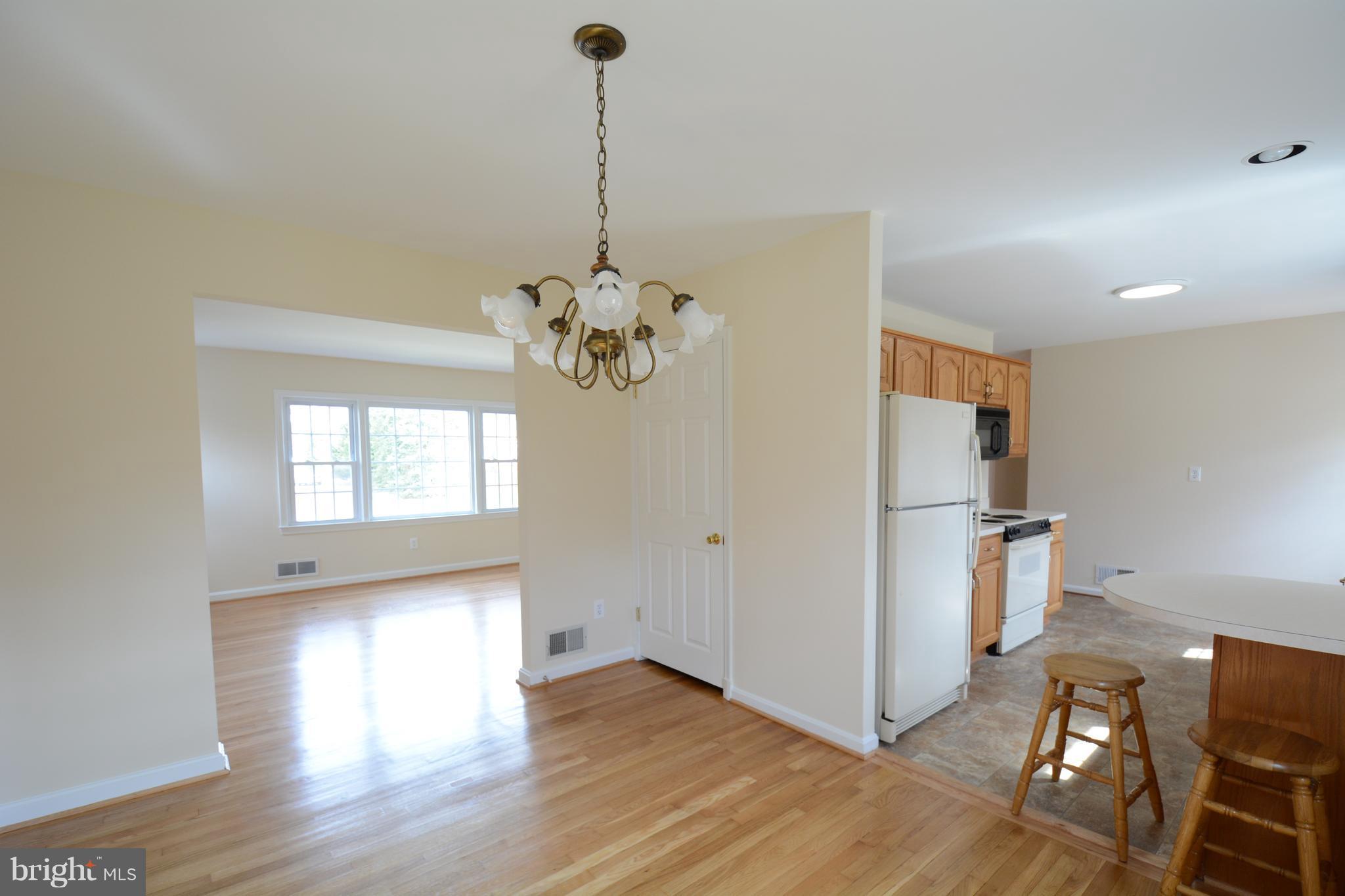 6505 Kalmia Street Springfield, VA 22150 - Photo 6 of 30 a view of empty room with wooden floor and kitchen view
