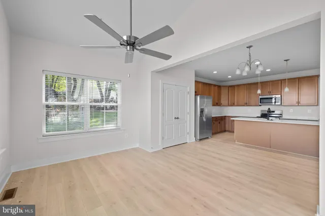 a view of a kitchen with kitchen island a sink stainless steel appliances and cabinets
